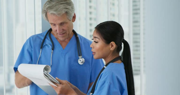 Two friendly medical doctors or nurses working together in hospital