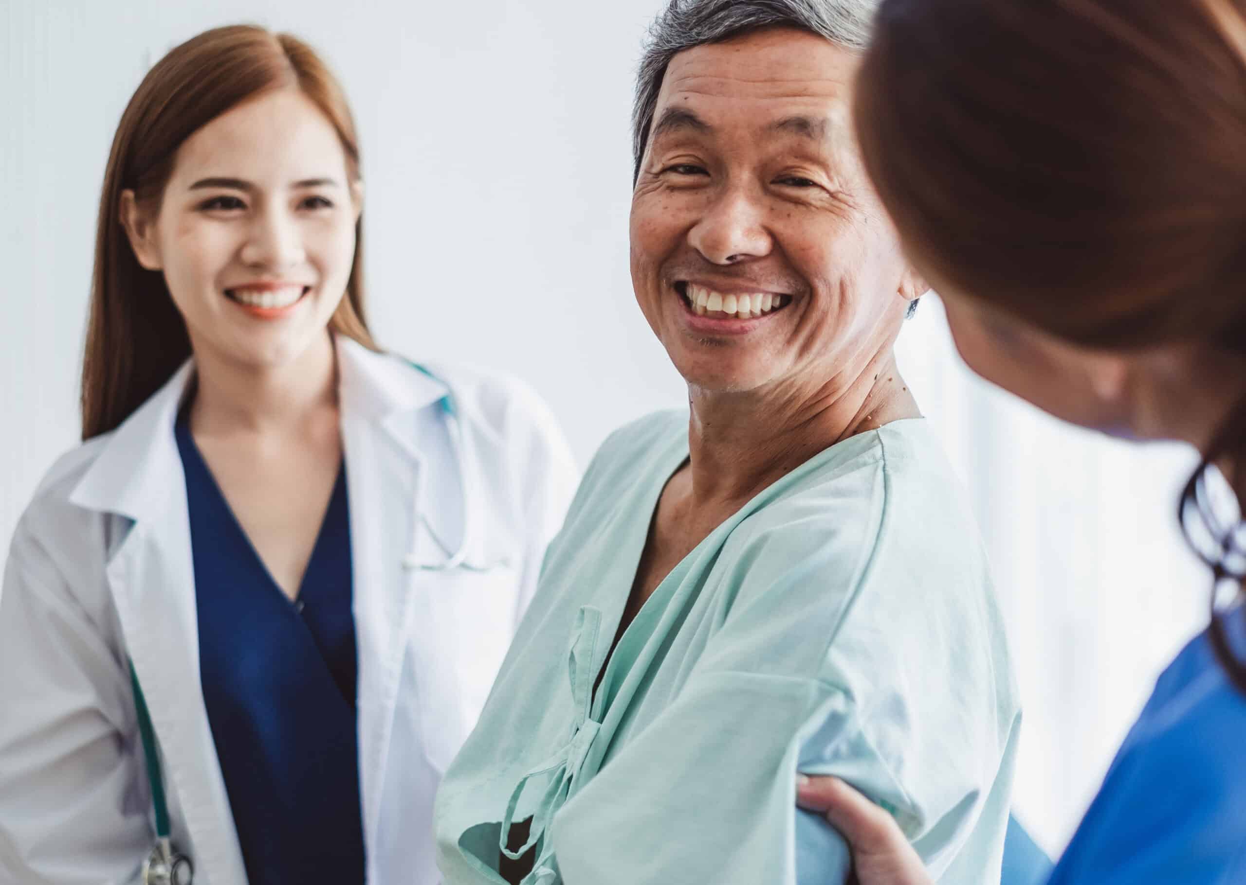 Asian doctor woman and nurse encourage disabled old man patient sitting on wheelchair at hospital, asian medical concept
